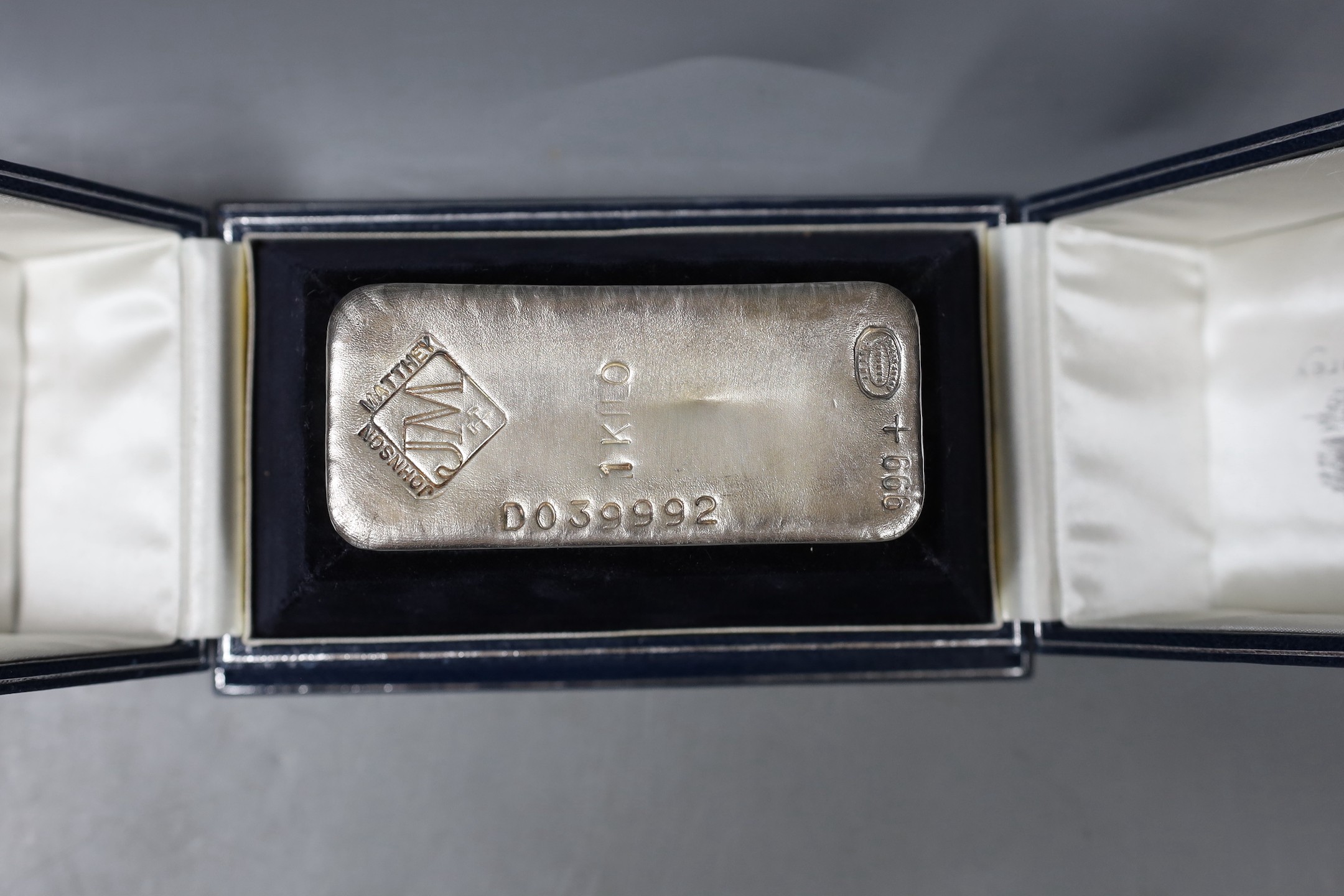 A modern Johnson & Matthey silver 1kg ingot, 11.3cm, with engraved presentation inscription, in Asprey fitted case.